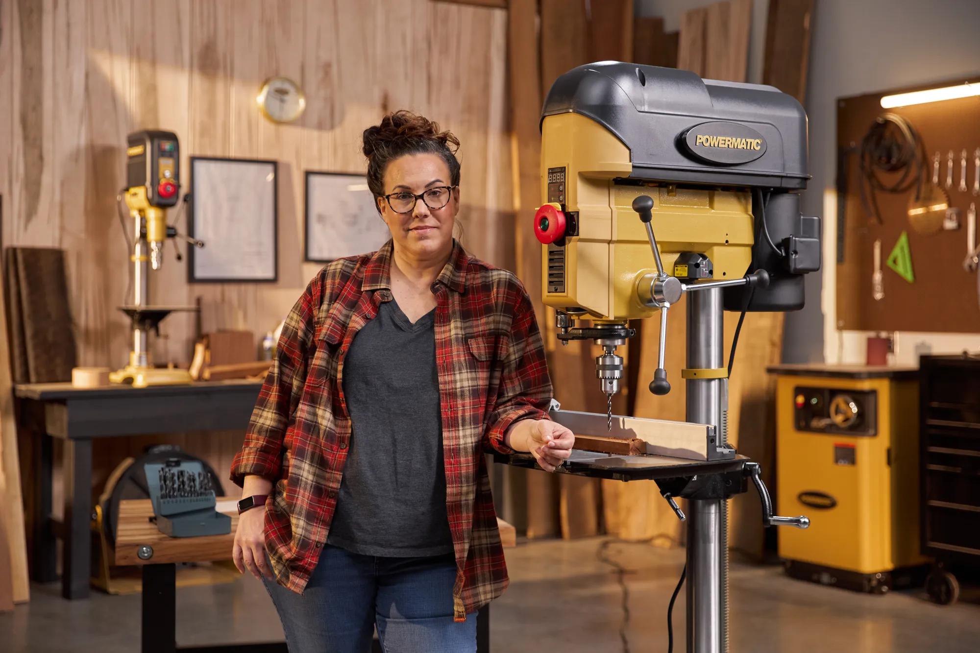 Woodworker standing next to a Powermatic drill press in a workshop